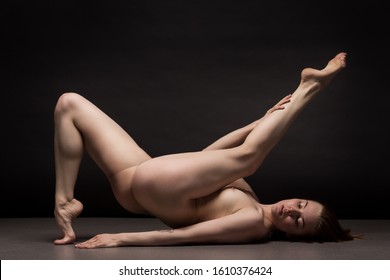 Athletic natural woman body on dark background. Nude woman Yoga.   