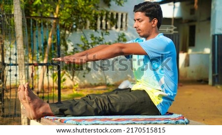 Athletic Rajasthani man in a sporty uniform engaged in yoga at outdoor. Yoga instructor, in outdoor exercise