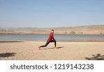 Athletic runner doing stretching exercise, preparing for morning workout in the park