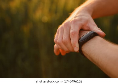 Athletic runner start training on fitness tracker or smart watch and looking forward on horizon. Trail running and active lifestyle concept.