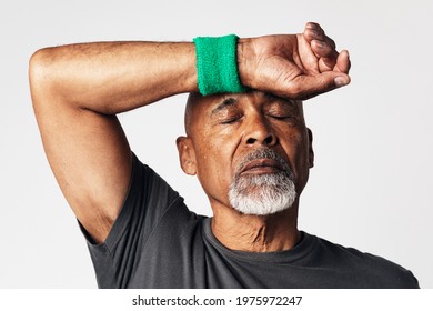 Athletic senior mean wiping off sweat from his forehead - Powered by Shutterstock