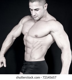 Athletic Sexy Attractive Male Body Builder, Demonstrating Contest Pose. Studio Shot