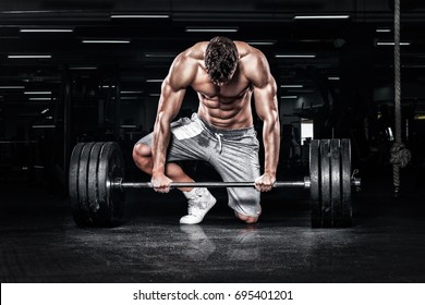 Athletic shirtless young sports man - fitness model with barbell in gym. - Powered by Shutterstock