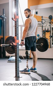 Athletic Sportsman With Artificial Leg Working Out With Barbell At Gym