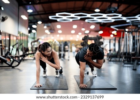 Athletic Sportsman and Sportswoman Doing Push Ups Together at Fitness Gym: Strength, Unity, and Motivation Foto d'archivio © 
