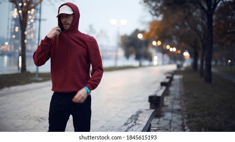 Athletic sporty man training in hoodie sweatshirt in urban city park. - Powered by Shutterstock