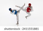 Athletic, strong young men, taekwondo athletes in motion, fighting, training isolated over white background. Concept of martial arts, combat sport, competition, action, strength, education