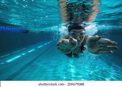Athletic swimmer training on her own in the swimming pool at the leisure centre - Shutterstock ID 209679088