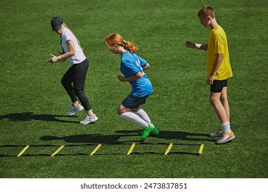 Athletic Training on Field Kids wearing sports gear engaged in challenging footwork exercise with agility ladder equipment. Concept of sport, school, childhood, hobby, active lifestyle - Powered by Shutterstock