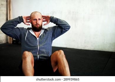 Athletic White Man Concentrating During Situps In Gym