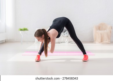 Athletic Woman Doing Stretching Exercise Her Hamstrings And Back Forward Bend Lean Down Aerobics Or Warming Up With Gymnastics At Home.