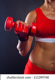 Athletic woman doing workout with weights on dark background