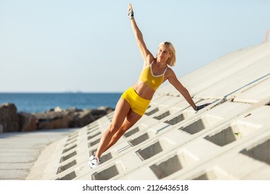 Athletic Woman Exercising From A Concrete Surface On The Beach. Fitness, Outdoor Aerobics Concept