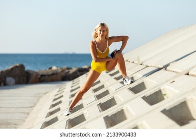 Athletic Woman Exercising From A Concrete Surface On The Beach. Fitness, Outdoor Aerobics Concept