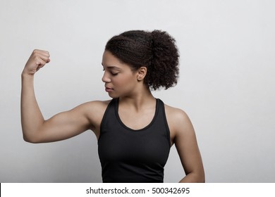 Athletic Woman Flexing Her Arm Muscle In Studio