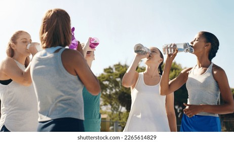 Athletic woman, friends and drinking water for hydration during sports workout, training or practice together outside. Group of sporty women staying hydrated for healthy sport exercise in nature - Shutterstock ID 2265614829
