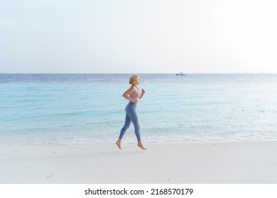 Athletic woman jogging on the beach. - Shutterstock ID 2168570179