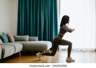 Athletic woman legs lunges workout at home, squats. Home workout.. Slim female stretching at home and weight loss workout in a living room.