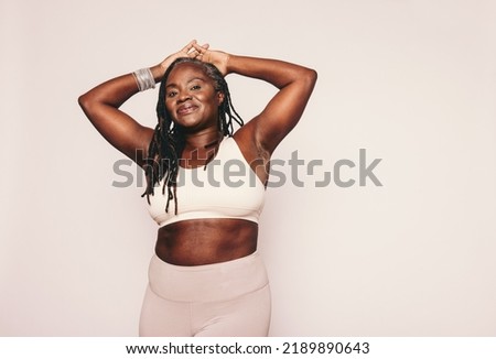 Mature woman in sportswear using smartphone in modern city setting