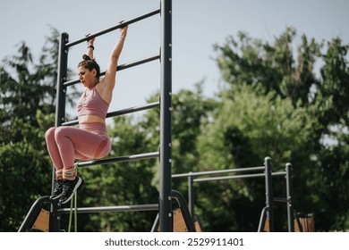 Athletic woman performing calisthenics exercises on monkey bars in an outdoor park. Focus on strength and fitness. - Powered by Shutterstock