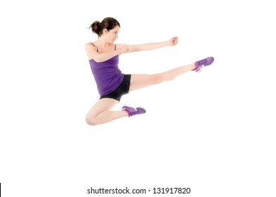 Athletic Woman Performing A Flying Side Kick Isolated On A White Background