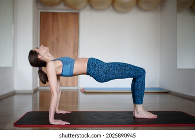 Athletic Woman Performs Reverse Plank Exercise In Gym