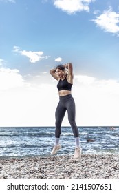 Athletic Woman Practicing Jumping, Doing Burpee Exercise On The Beach. Functional Outdoor Training