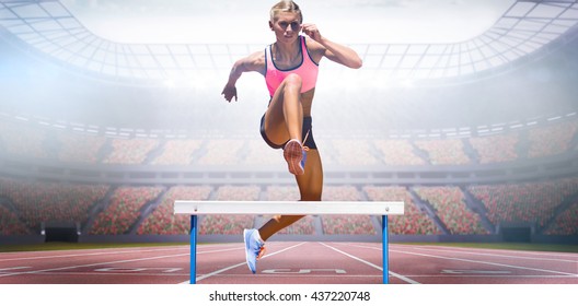 Athletic woman practicing show jumping against view of a stadium