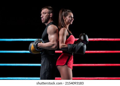 Athletic Woman In Red Shorts And Top Posing With A Trainer In The Ring. Boxing And Mixed Martial Arts Concept. Mixed Media