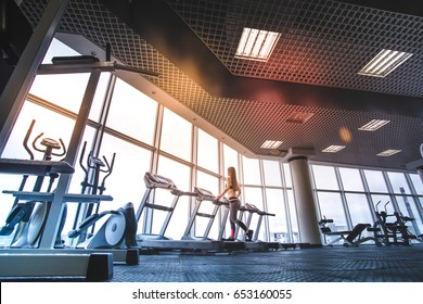 The athletic woman running on the treadmill in the gym