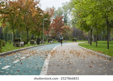 Athletic woman running in the park in the morning hours, early autumn, overcast - Powered by Shutterstock