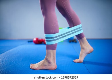 Athletic Woman In Sportswear Barefoot Using Thick Elastic Fabric Workout Bands For Stretch Fitness Booty Loops, Band For Gym, Weights Squats, Training Muscles. Slim Girl In Good Shape.