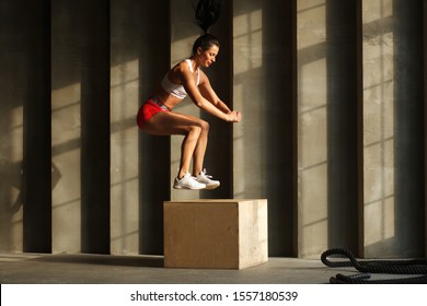 athletic woman in sportswear jumping on crossfit box in fitness gym - Powered by Shutterstock