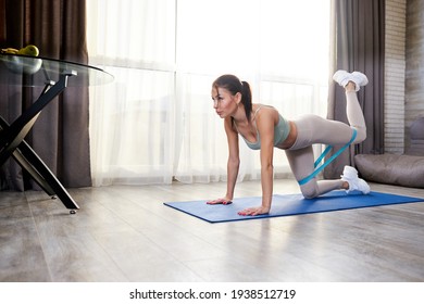 Athletic Woman In Sportswear Using Thick Elastic Fabric Workout Bands For Stretching Body