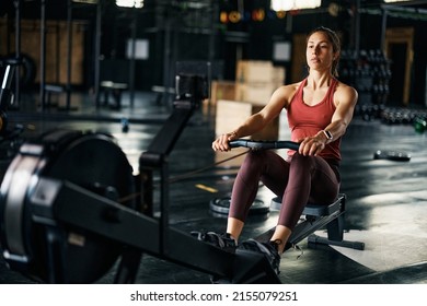 Athletic woman using rowing machine during cross training in a gym. - Powered by Shutterstock