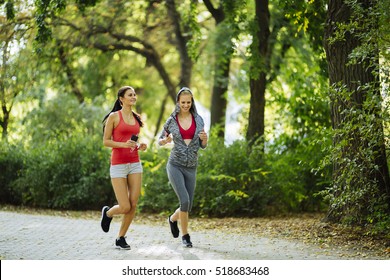 Athletic Women Exercising By Jogging In Nature