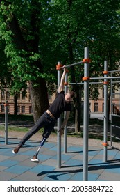 Athletic Young Man With Artificial Leg Working Out On A Bars