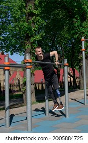 Athletic Young Man With Artificial Leg Working Out On A Bars