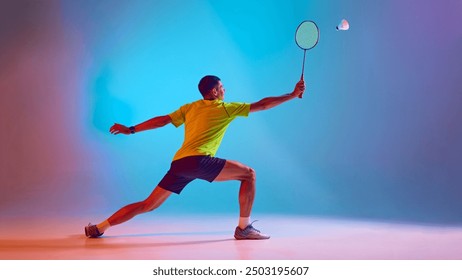 Athletic young man, badminton player in motion training, preparing for game against gradient blue pink background in neon light. Concept of sport, competition, active and healthy lifestyle - Powered by Shutterstock