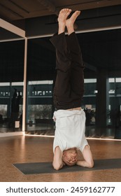 An athletic young man does exercises in the fitness room. A professional guy does yoga in the gym.