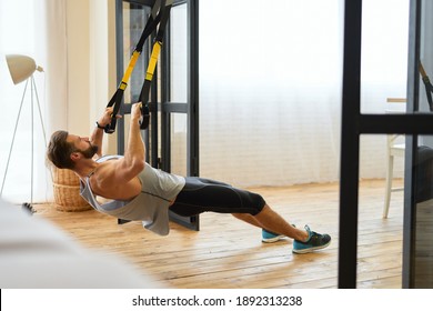 Athletic young man doing exercise with elastic fitness band - Shutterstock ID 1892313238