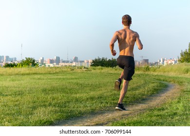 Athletic young man running in the morning outdoors. - Shutterstock ID 706099144