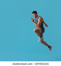 Athletic Young Man Running On Turquoise Background, Side View