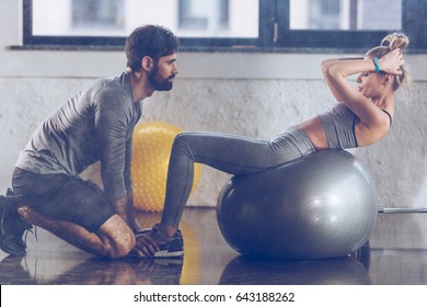 Athletic Young Sportswoman Doing Abs On Fitness Ball At The Gym, Fitness Couple Gym Concept