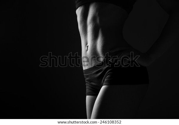 暗い背景に美しい腹筋を持つ体育の若い女性 白黒の写真 の写真素材 今すぐ編集