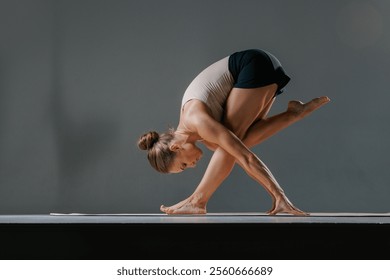 An athletic young woman performs the stretching pose Baddha Parsvakonasana, or Bound Side Angle Pose, during her daily yoga practice at a studio. - Powered by Shutterstock