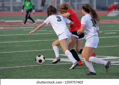 Athletic young women playing in a competitive university interscholastic league high school soccer match playoff game - Powered by Shutterstock