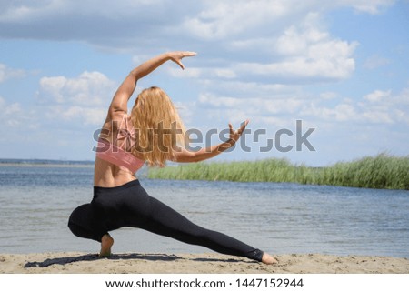 Athletic young yogi woman practicing yoga outdoors on the beach on sunshine.  Hands in shape of moon. Body positive female training, practicing yoga concept