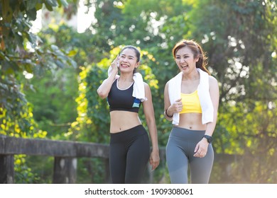 athletics couple woman having fun and taking a break after jogging or exercising together in public park - Powered by Shutterstock