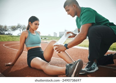 Athletics, injury and people with bandage on track for training, first aid or leg support in sports. Field, runner and paramedic with wrap for outdoor exercise sprain, accident or protection of joint - Powered by Shutterstock